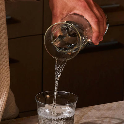 Holcomb Studio Teeter Carafe, Clear | Hand-Blown Glass Beverage Pitcher with Ash Wood Top | Modern Carafe for Water, Juice, or Cocktails | Elegant Serveware & Hostess Gift Home Décor Accent 10.4"H